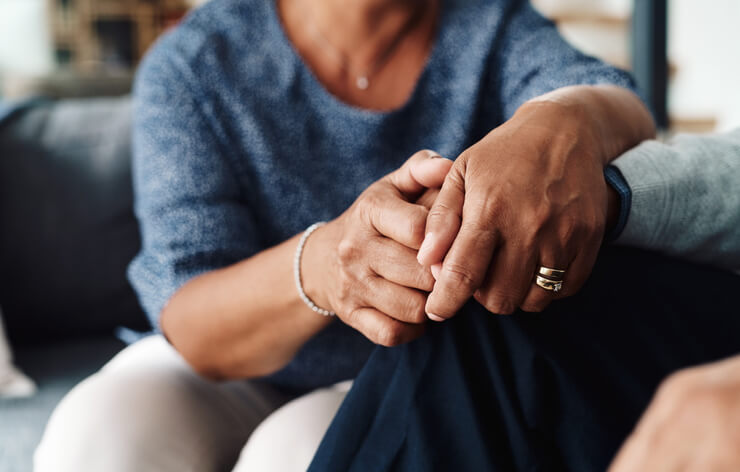 Woman holding elderly woman's hand