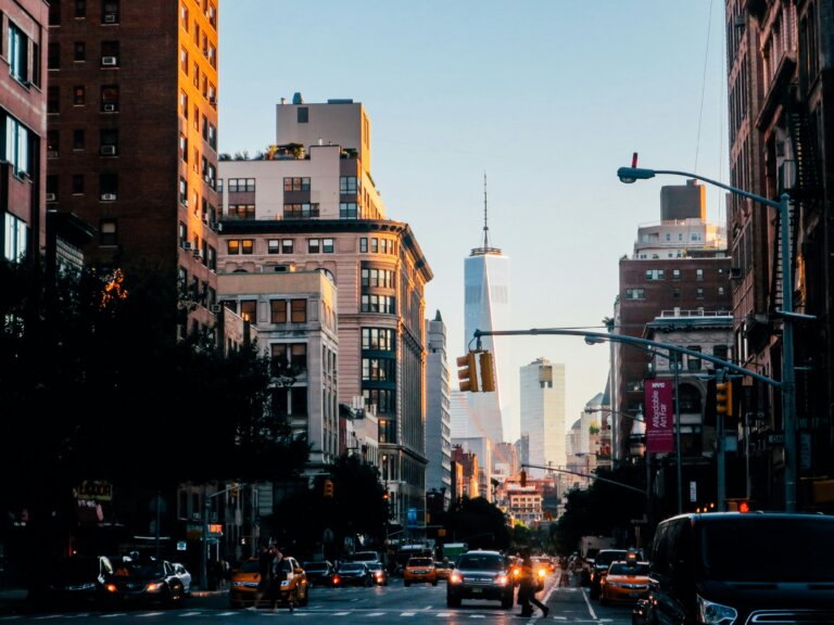 Traffic on a Manhattan street with One World Trade Center in the distance